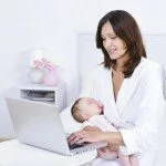 Женщина за ноутбуком с ребенком